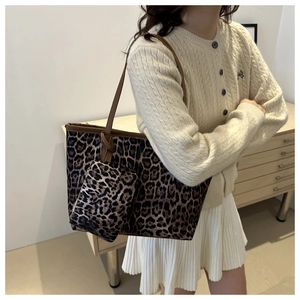 Detail van luipaardprint tote bag met bruine geknoopte schouderriem en mini tas