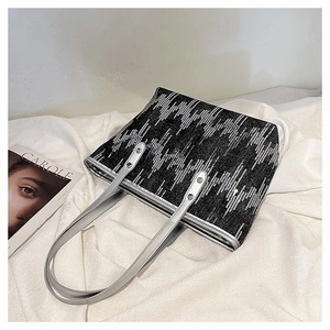 Detailed close-up of a black tote bag featuring geometric silver sequin patterns