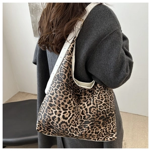 Detail of leopard print tote bag with adjustable white wide shoulder strap and metal buckle