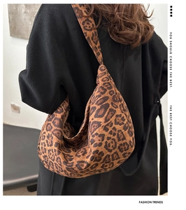 Leopard print hobo bag with wide shoulder strap shown on model in a side view