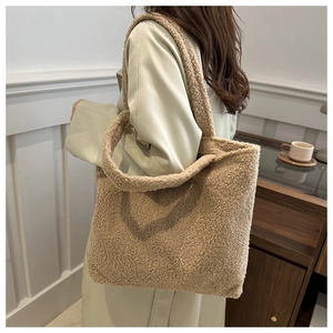 Close-up of camel faux shearling tote bag showing fluffy texture and soft shoulder strap