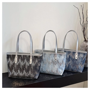 Detail of glitter wave patterns and silver handles on luxury sequin tote bags