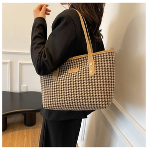 Detail of houndstooth tote bag showing premium textile texture and brown leather strap