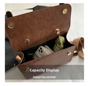 Intérieur du sac vintage marron montrant l'espace pour parapluie et téléphone