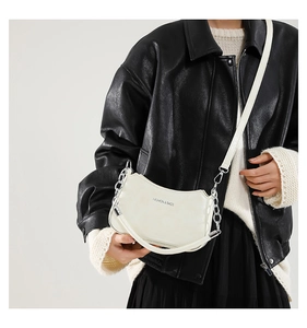 Detail of off-white crescent bag with silver chain and Fashion & Bags text on leather