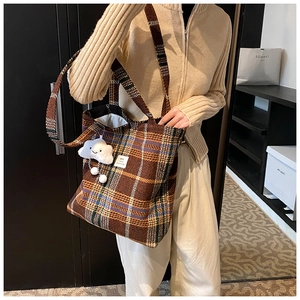 Detail of vintage plaid tote bag with a white plush cloud charm and wide shoulder strap