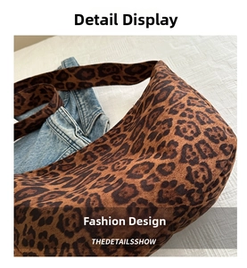Close-up of leopard print tote bag texture with wide shoulder strap and denim accent