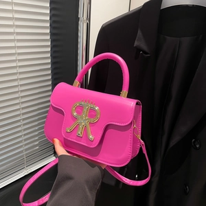 Magenta Handtasche in Quadratform mit goldenem Logo und verstellbarem Schultergurt