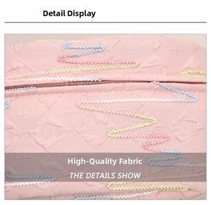 Detail of pink fabric chest bag with quilted texture and colorful wavy embroidery