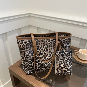 Grote shopper met luipaardprint en bijpassende kleine tas op houten tafel