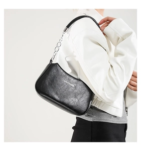 Detail of dark grey oil wax leather shoulder bag with fashion text and chain strap