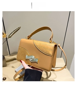 Détail d'un sac à bandoulière marron avec boucle argentée et poignée renforcée