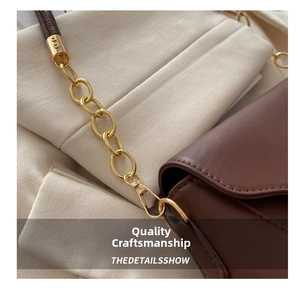Detail of brown leather bag with golden chain strap and neat stitching craftsmanship