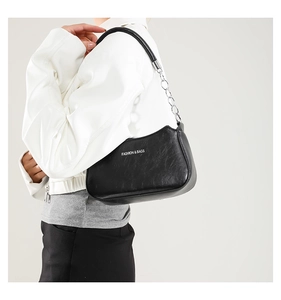 Side view of black matte underarm bag with silver chain strap and fashion logo