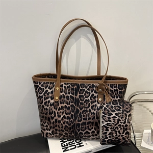 Grote shopper met luipaardprint en bijpassende portemonnee op een leren stoel