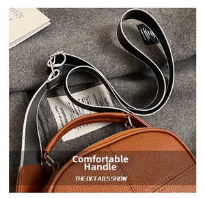 Detail of brown litchi pattern leather bag with colorful woven shoulder strap