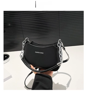 Detail of black crescent shoulder bag with silver chain and FASHION & BAGS logo