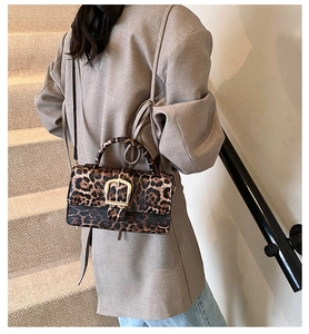 Detail showing leopard print texture and golden square buckle on the shoulder bag