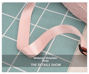 Detail of pink widened nylon shoulder strap on corduroy bag with soft woven texture