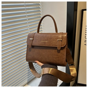 Détail du sac à main vintage marron en PU avec breloque cœur et bandoulière