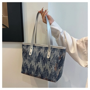 Detail of glittery sequin texture and silver leather handles on this tote bag