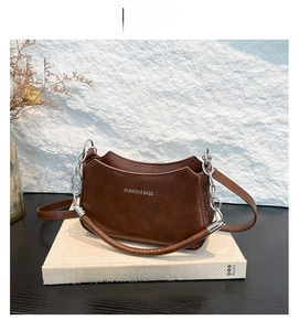 Brown faux leather crescent bag with silver chain strap and fashion text detail