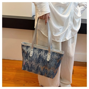 Detail of dark blue canvas tote bag with metallic sequins and silver leather straps