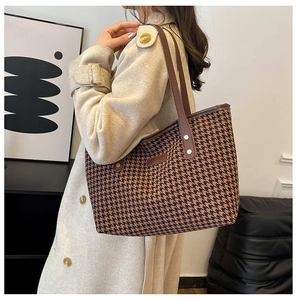 Classic houndstooth tote bag detail featuring leather handles and a spacious structure