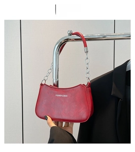 Detail of red crescent bag featuring silver Fashion and Bags logo and metal chain strap