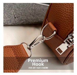 Detail of silver metal swivel hook and brown lychee grain leather on a vintage pillow bag