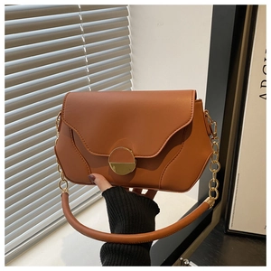 Détail du sac en similicuir marron caramel avec fermoir aimanté doré et bandoulière chaîne
