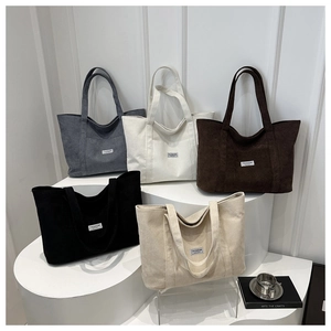 Corduroy tote bags in five neutral colors displayed on white tiered steps for daily use