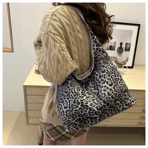 Grand sac cabas léopard pour femme porté par un mannequin dans un décor élégant