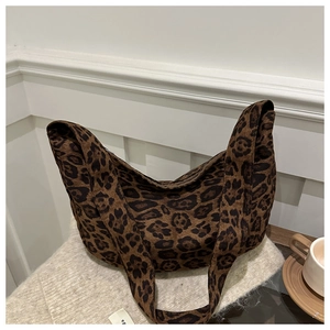 Macro shot of the brown leopard print fabric and wide shoulder strap on this tote bag