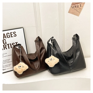 Detail of vintage tote bags in brown and black leather with plush smile charms