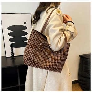Detail of checkered tote bag in brown and black tweed fabric worn with a wool coat