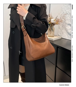 Close-up of a retro brown crescent hobo bag with adjustable strap and gold hardware