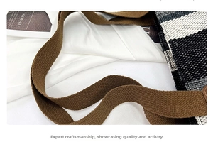 Close-up of striped canvas tote bag showing thick brown straps and woven texture