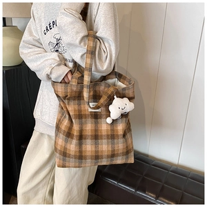 Detail of vintage plaid tote bag with wool texture and cute white cloud charm