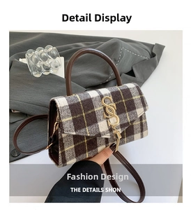 Close-up of retro plaid fabric texture and golden interlocking S-buckle with tassels