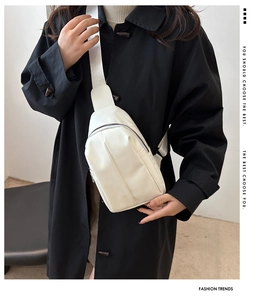 White minimalist PU leather crossbody chest bag shown on model with wide shoulder strap