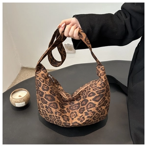 Close-up of leopard print hobo bag with a zipper closure and wide shoulder strap detail