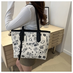 Detail shot of white tote bag with black graffiti bear prints and slim shoulder straps