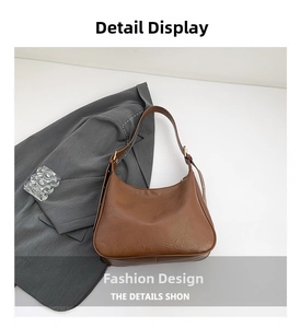 Detailed macro view of the brown leather half-moon bag with adjustable golden buckle