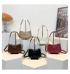Five assorted vintage crescent bags on geometric stands with chic leather and chain straps
