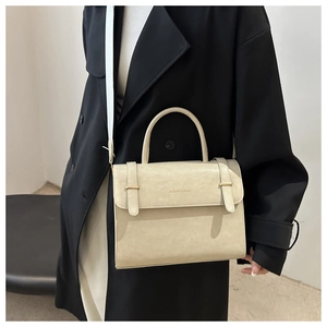 Détail du sac bandoulière crème avec imprimé tendance et élégant fermoir doré