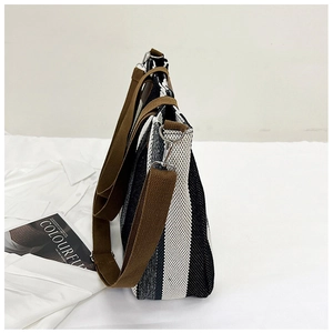 Detail of spacious black and white striped canvas tote bag with adjustable brown strap