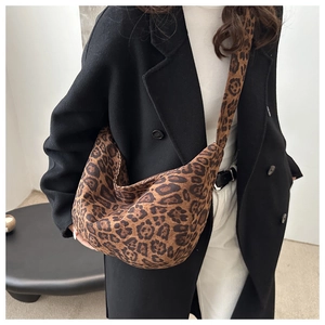 Close-up of leopard print tote bag with brown pattern worn over a black winter coat