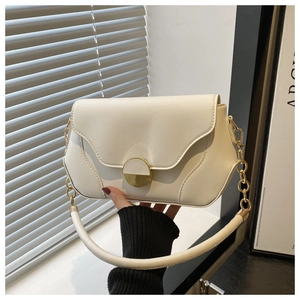 Détail d'un sac à bandoulière blanc crème avec boucle dorée et bandoulière chaîne