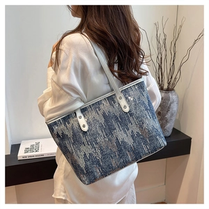 Close-up of sparkling blue and silver sequins on large canvas tote with white straps